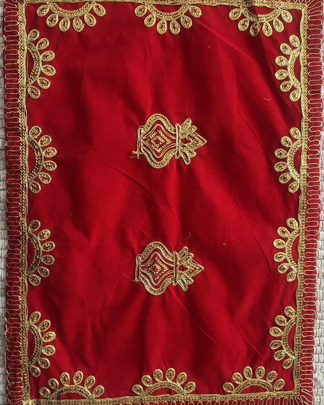 A red velvet puja aasan with gold kalash embroidery