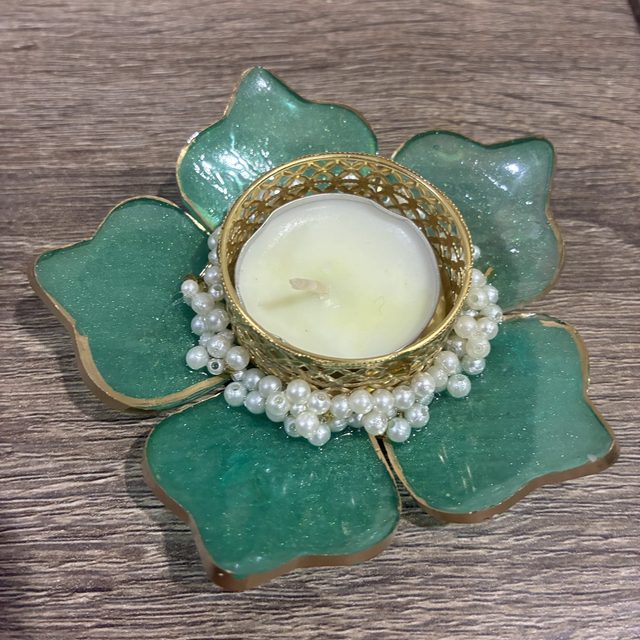 A green flower-shaped tealight holder with a pearl rim