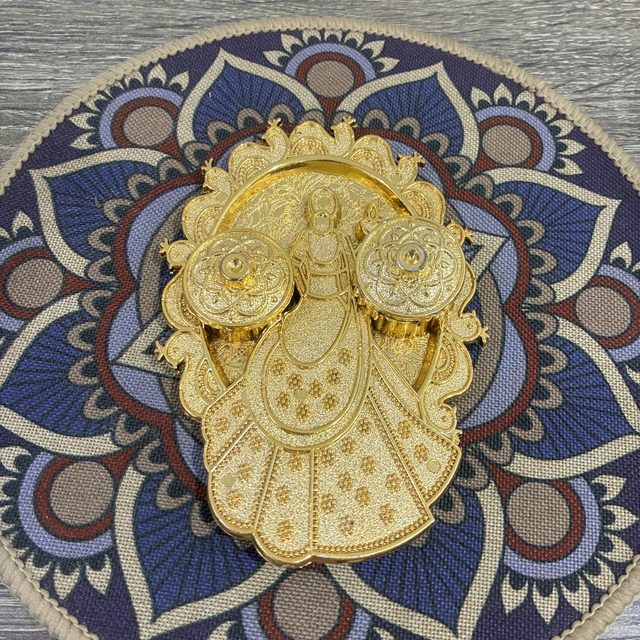 A gold Lakshmi figure holding two lidded haldi-kumkum boxes