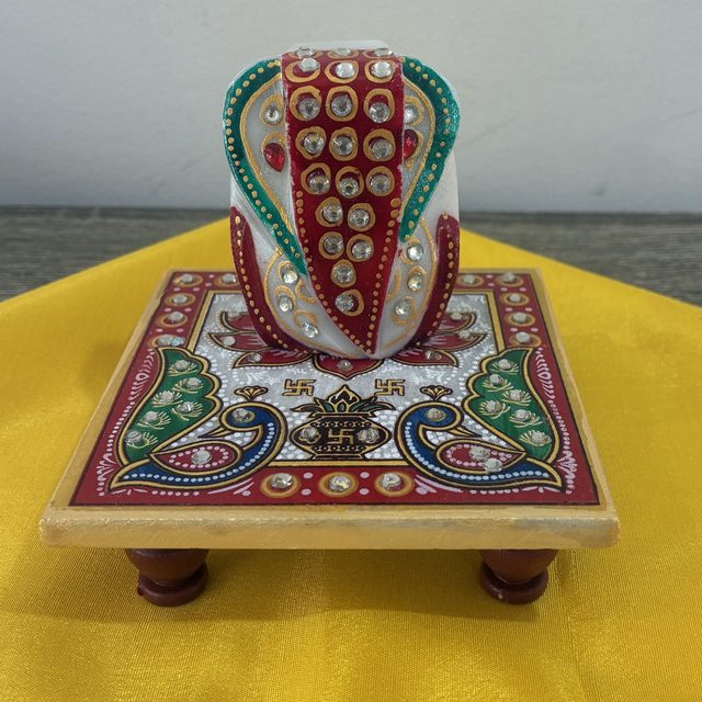 A painted marble Ganesha on a matching chowki